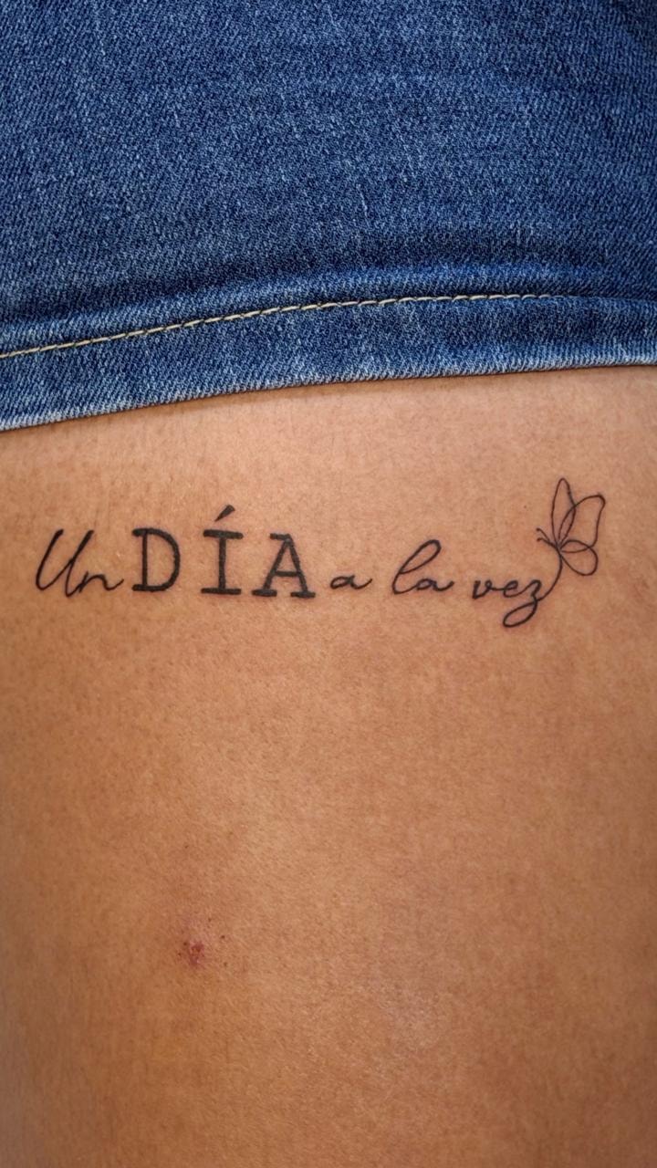Tatuaje texto mariposa costillas — Top Level Studio